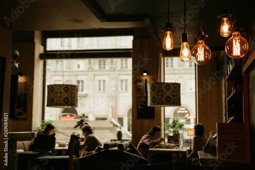 Slika na platnu Cozy cafe atmosphere. Focus on bulbs