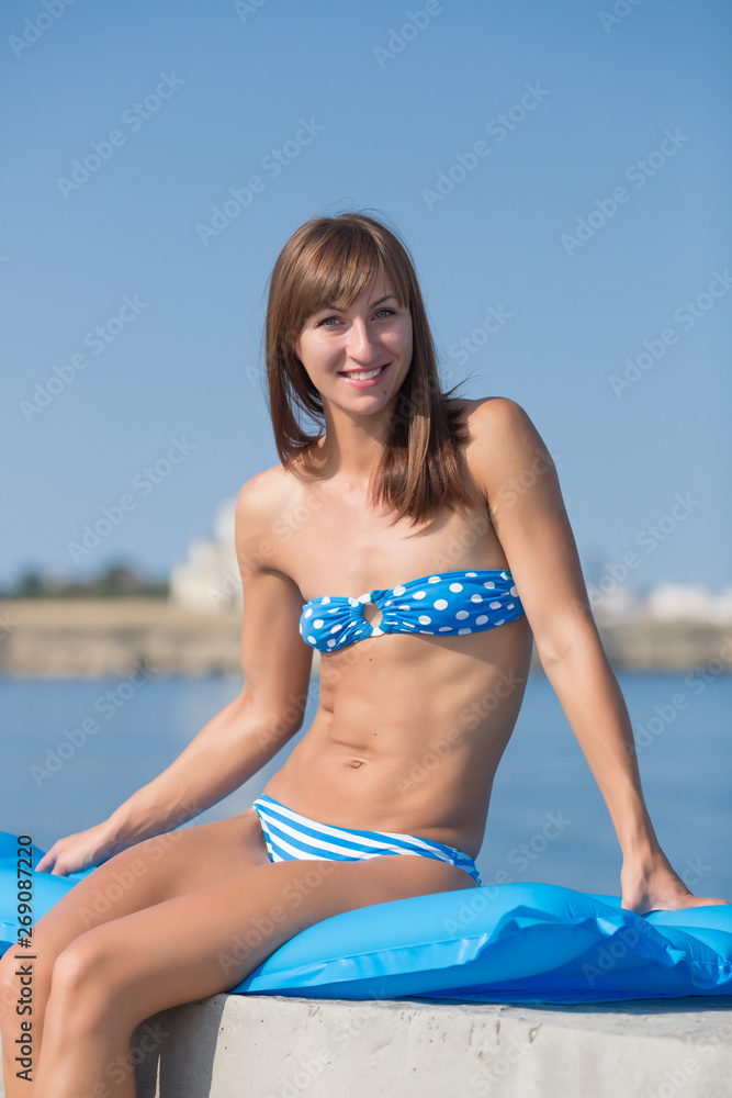 Slim tall girl in blue bikini at the sea Stock Photo