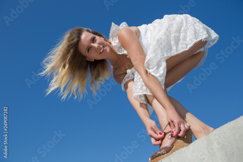 Female person in white dress bends