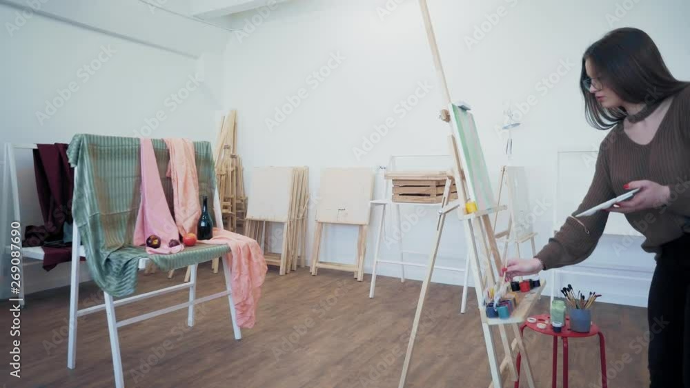 Cute girl with a brush draws a picture Cute girl with a brush draws a picture