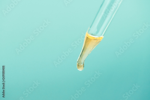 Glass pipette with cosmetic oil essence close up