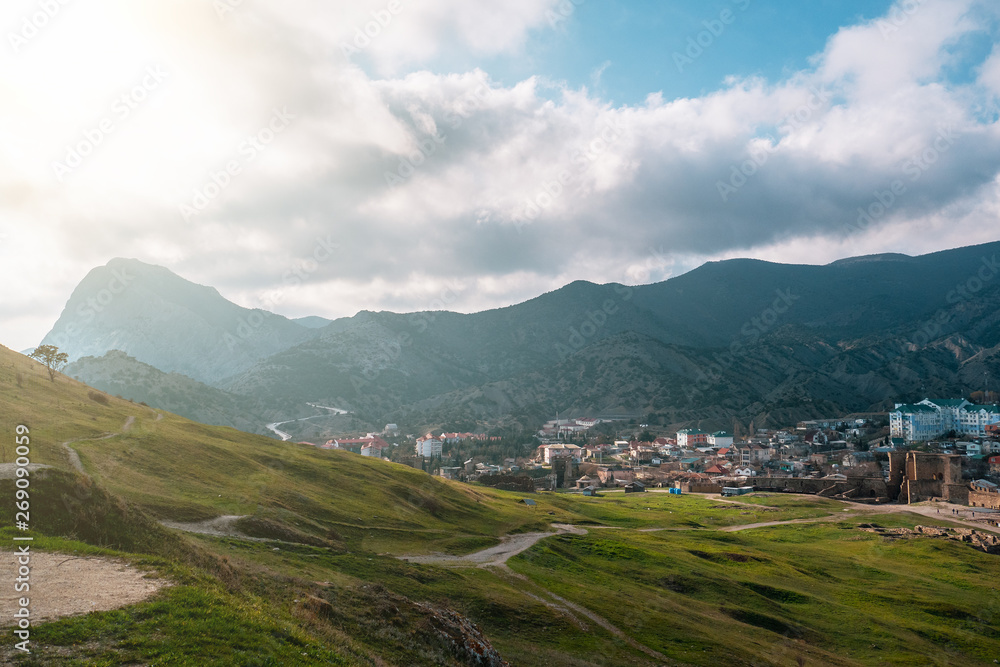 Panorama of mountains and small town Sudak in warm sunny day, beautiful nature travel landscape