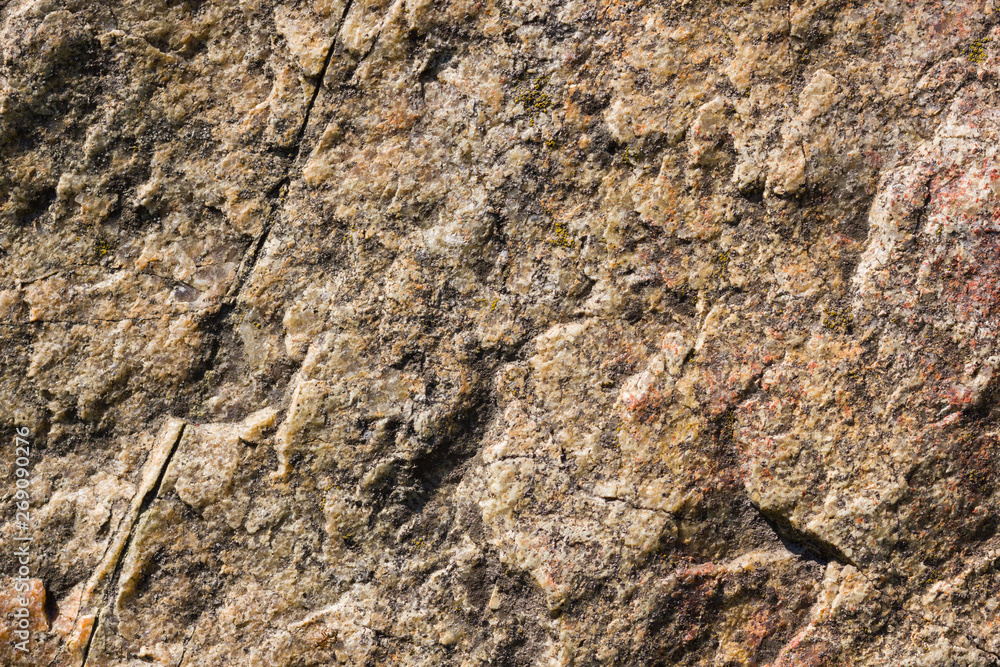 Background of granite. Texture of granite stone. Pattern of roughened surface. Texture of brown stone