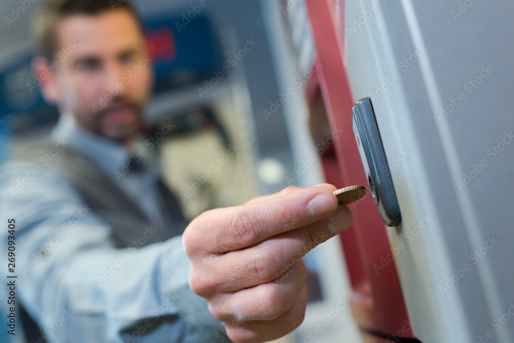 man inserting coin in to a vending machine man inserting coin in to a vending machine