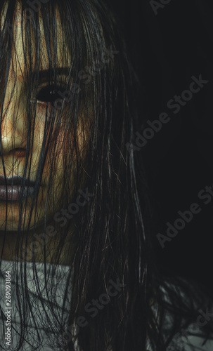 Scary cursed girl with black eyes on dark background copy space
