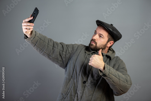 Caucasian man 35 years old doing selfie, studio shot. Idea - village dweller and modern technology photo