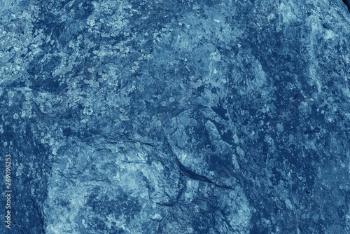 Vintage blue background. Rough painted wall of sapphire color. Imperfect plane of blue colored. Uneven old decorative toned backdrop of cyan tint. Texture of sapphirine hue. Ornamental stony surface.