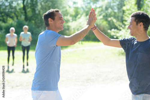active fit friends high five in celebration after completing workout