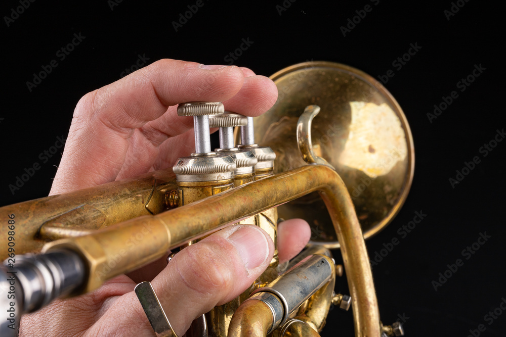 Obraz premium Old trumpet on a dark wooden table. Wind instrument in the old style.