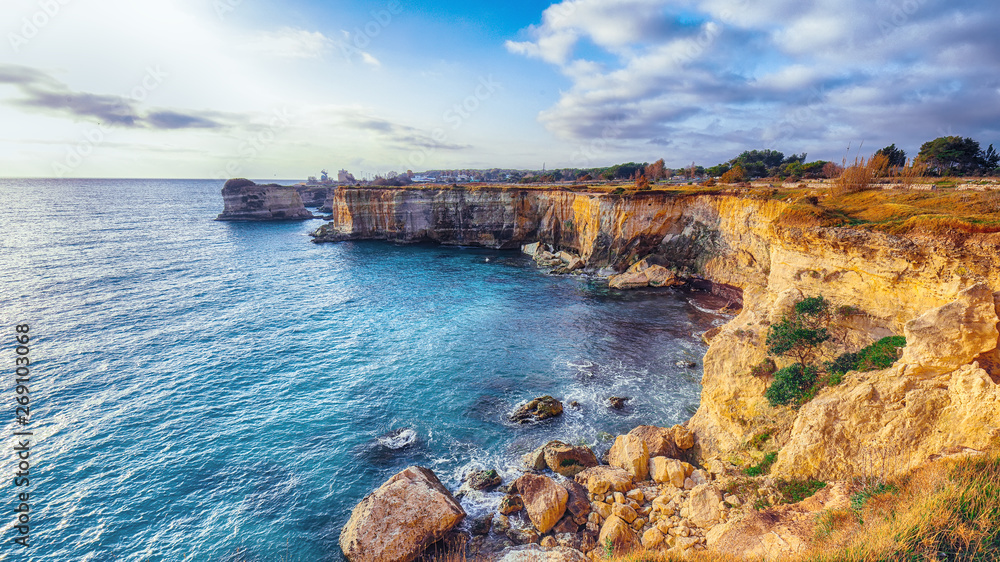 Picturesque seascape with cliffs rocky arch and stacks (faraglioni) at Torre Sant Andrea