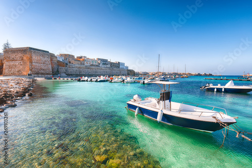 фотографія Several fishing boats at the Otranto harbour - coastal town in Puglia with turqu