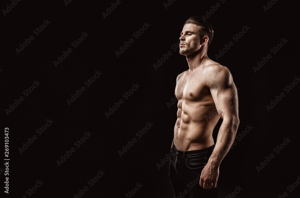 Muscular model young man on dark background. Fashion portrait of strong  brutal guy with trendy hairstyle. Sexy naked torso, six pack abs. Male  flexing his muscles. Sport workout bodybuilding concept. Stock Photo |