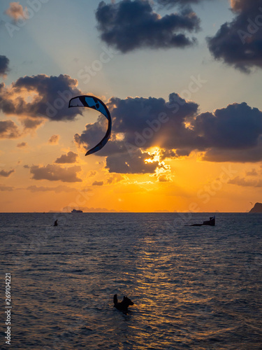 Silhouette of a dog and flying kites on the background of the setting sun and clouds. Koh Phangan. Thailand