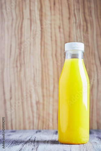 Bottle of orange juice on wooden background. Transparent plastic bottle with orange background. Summer is refreshing with very cold juice. copy space. citrus drink.