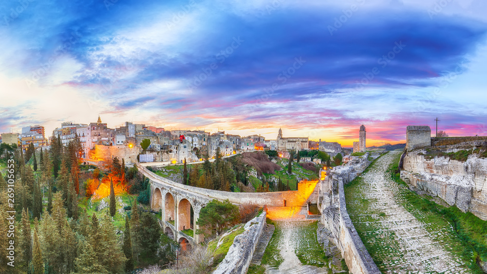 Naklejka premium Gravina in Puglia ancient town, bridge and canyon at sunrise