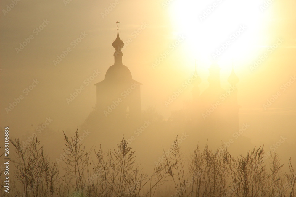 Church silhouette in rising sun misty morning