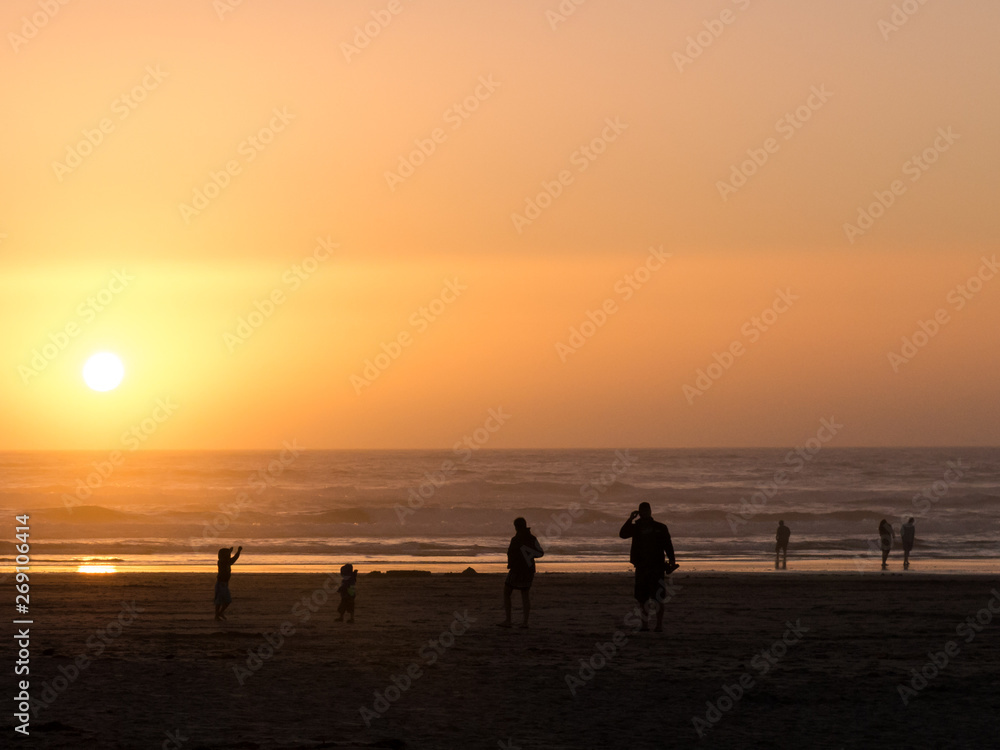 Silhouette of people at the Oregon coast during sunset