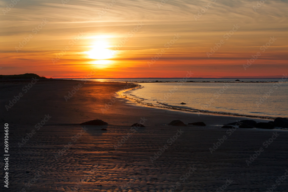 Naklejka premium Reddish brown foggy sunset by the shore