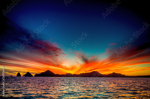 Beautiful Sunset of Seascape with Mountains silhouets. Sea off the Coast of Cabo San Lucas. Gulf of California (also known as the Sea of Cortez, Sea of Cortes. Mexico. Sunset over Cabo San Lucas photo