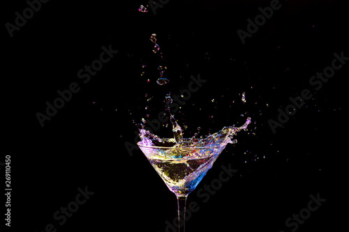 Splash Photography. Burst of Colorful Liquid in Wine Glass. Isolated Over Black.