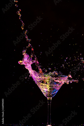 Splash Photography. Droplets Along With Burst of Colorful Liquid in Wine Glass. Isolated Over Black.