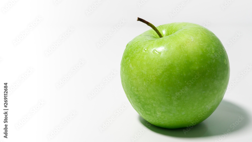 Delicious fresh Granny Smith apple on a white background with space to left