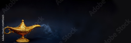 Magic lamp. A Vintage magical lamp and smoke coming out on the black background, website banner size.