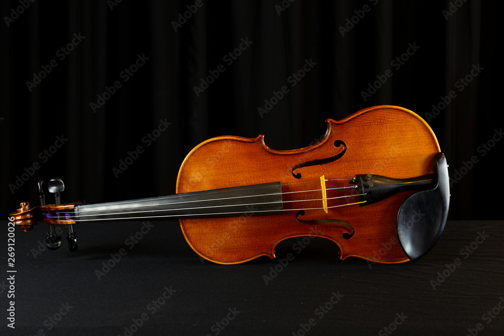 Fototapeta premium Close-up of wooden violin, stringed instrument with black background 