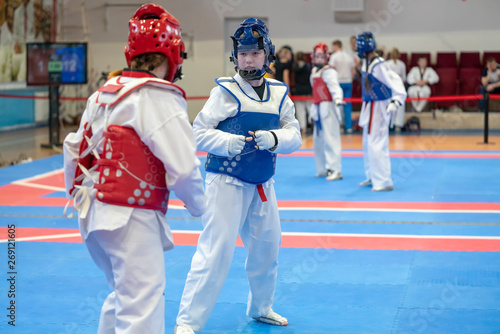 two girls in blue and red Taekwondo equipment are fighting at doyang