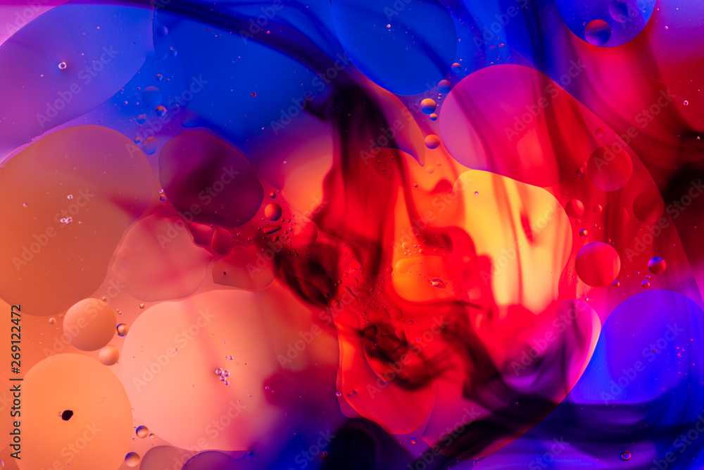 Fototapeta oleiste krople w wodzie z kolorowym tłem, zbliżenie