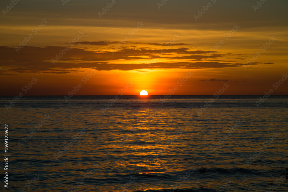Beautiful dramatic golden sky over the sea and reflection at sunset time in the summer