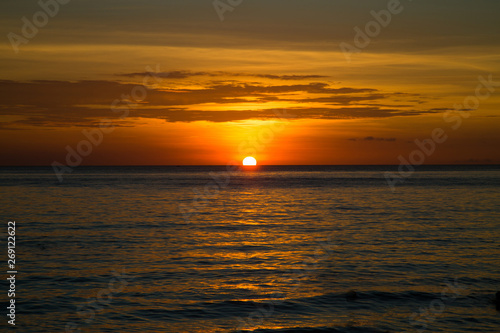 Beautiful dramatic golden sky over the sea and reflection at sunset time in the summer