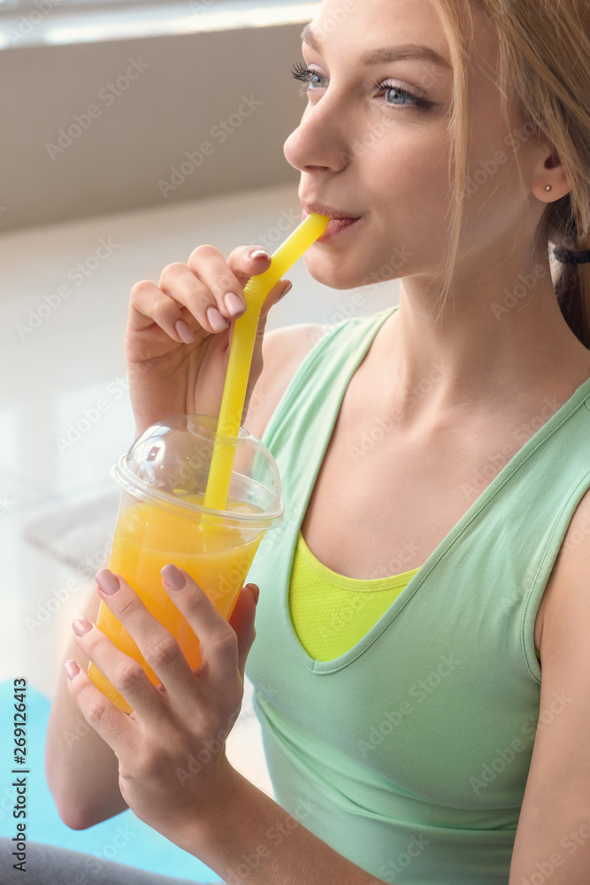 Sporty young woman drinking fresh juice at home Sporty young woman drinking fresh juice at home