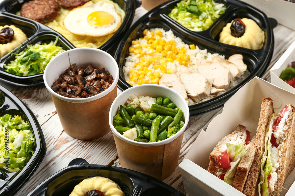 Containers with delicious food on table Containers with delicious food on table