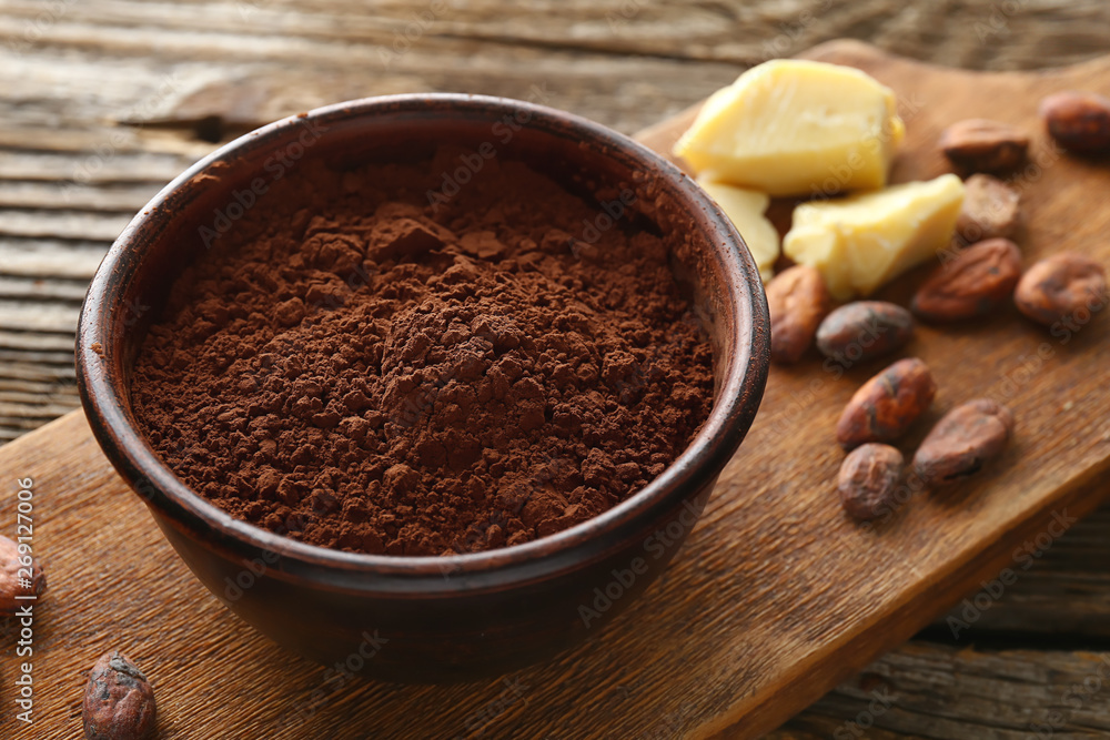 Bowl with cocoa powder on wooden background Bowl with cocoa powder on wooden background