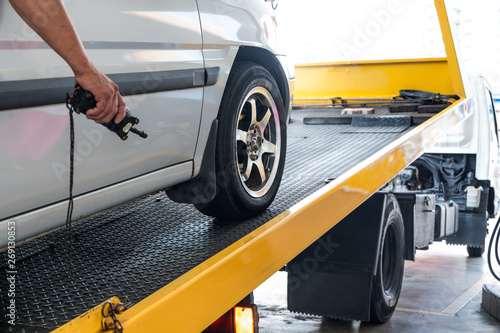 Bild auf Leinwand Closeup on car towed onto flatbed tow truck with cable