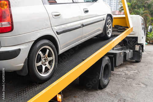 Broken down car towed onto flatbed tow truck with hook cable © ThamKC