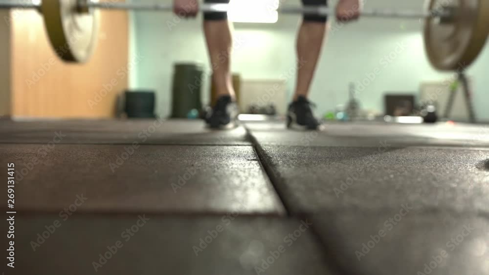 Young Male Weightlifter In Sneakers Takes The Barbell Young Male Weightlifter In Sneakers Takes The Barbell