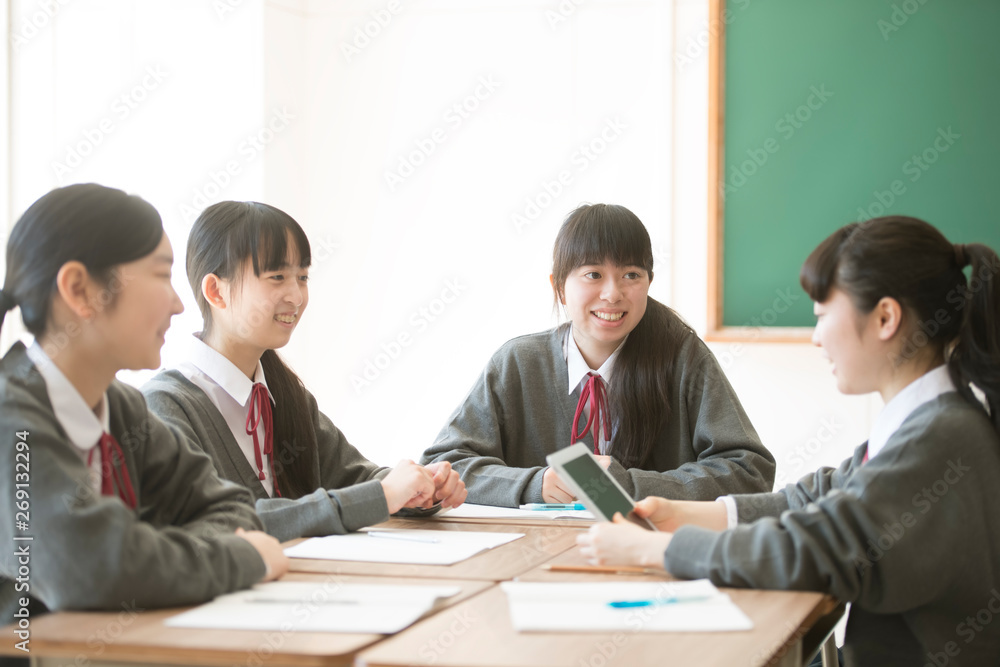 タブレットPCを使いグループ学習をする女子学生