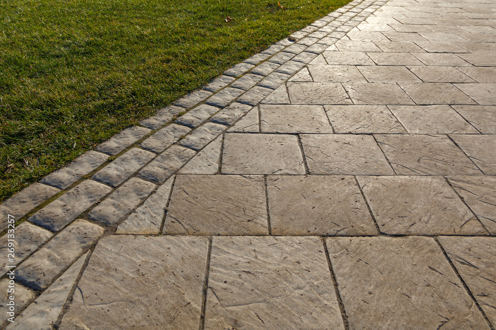 Surface paved with road tiles.  Concrete paving slabs of different shapes similar to natural stone.