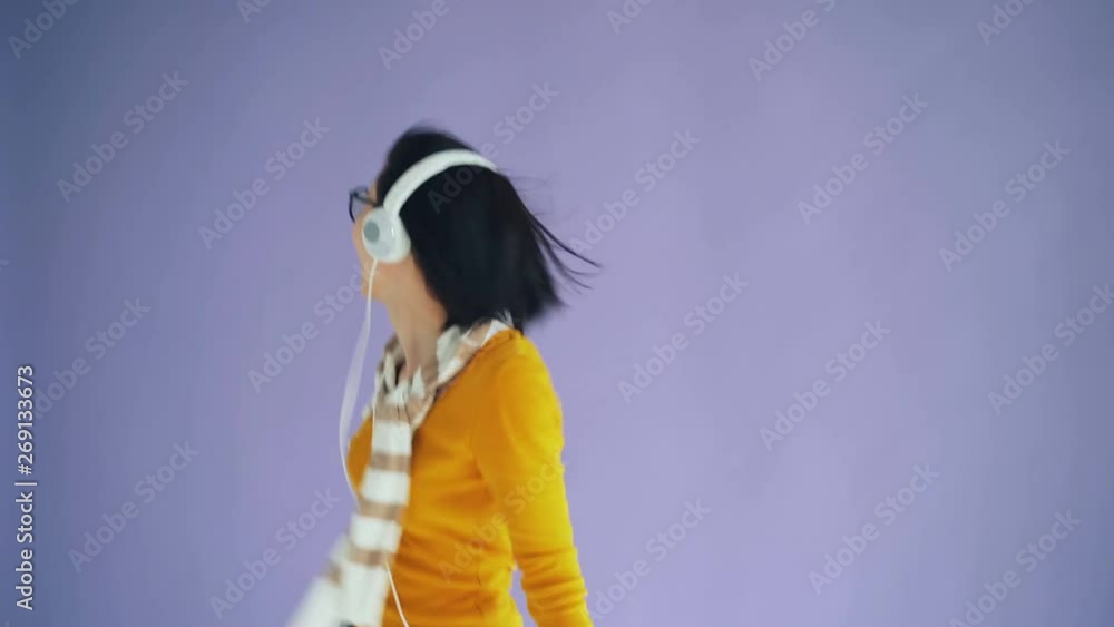 Portrait of excited woman in headphones dancing chilling listening to music having fun alone on purple background. Millennials and modern gadgets concept. Portrait of excited woman in headphones dancing chilling listening to music having fun alone on purple background. Millennials and modern gadgets concept.