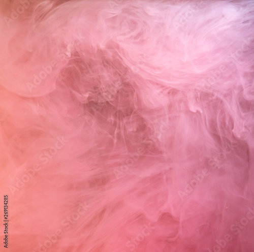 Pink paint dissolving into liquid, acrylic abstraction. Close up view. Blurred background. Acrylic ink mixing with liquid, abstract background. Pink clouds swirling in water, abstract pattern