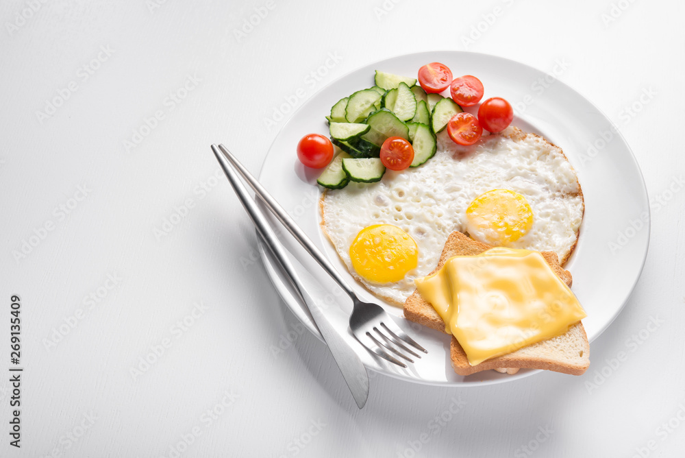 Plate of fried eggs and fresh vegetables, cheese toast Plate of fried eggs and fresh vegetables, cheese toast