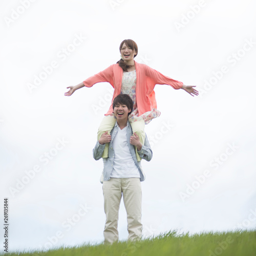 草原で肩車をするカップル