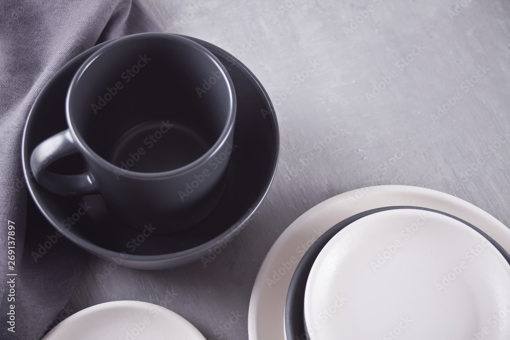 Empty black and white plates over gray table. Empty black and white plates over gray table.