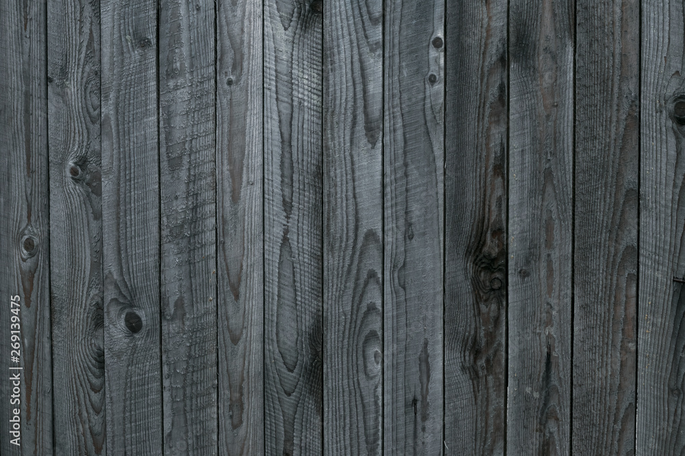 Naklejka premium Grunge texture of gray old wooden fence. Gray background of shabby wooden boards, planks. Surface of old shabby weathered wooden parquet, desk. Vintage pattern of rustic oak. Old dirty grain timber