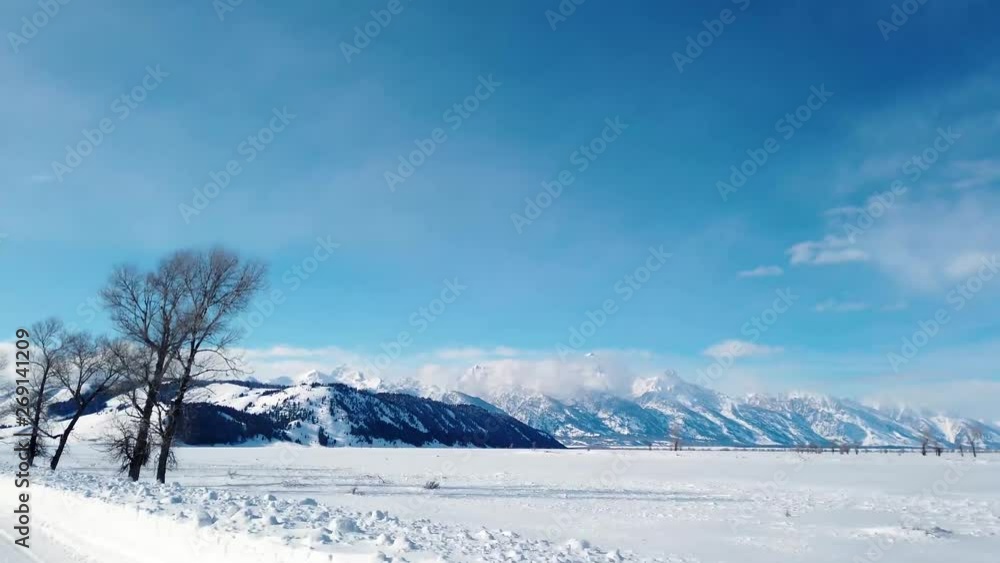 A fresh blanket of snow over a field with a mountain range in the background. A fresh blanket of snow over a field with a mountain range in the background.