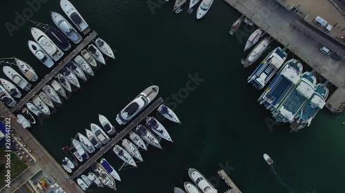 Ascending above boats docked at Porto Cristo in Mallorca in a spiral motion. Small sailing boat entering the port. photo