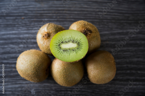 Pile of organic brown fuzzy kiwi fruit from New Zealand. The original green kiwi fruit also called Chinese gooseberry. Perfect for winter immunity to fight ills and chills and stay healthy. Vitamin C.