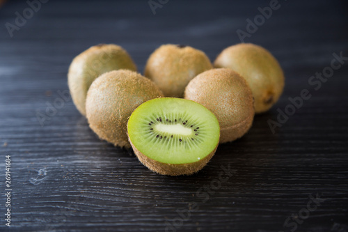 Pile of organic brown fuzzy kiwi fruit from New Zealand. The original green kiwi fruit also called Chinese gooseberry. Perfect for winter immunity to fight ills and chills and stay healthy. Vitamin C.